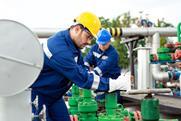 Two petrochemical workers inspecting pressure