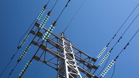 Metal electric pole on a blue sky background