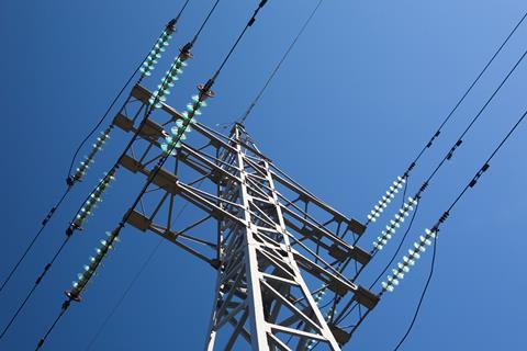 Metal electric pole on a blue sky background